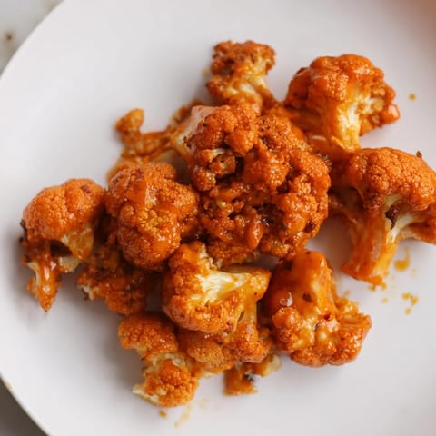 Crispy, golden-brown Buffalo Cauliflower Wings ready to enjoy with cooling ranch dressing and celery.