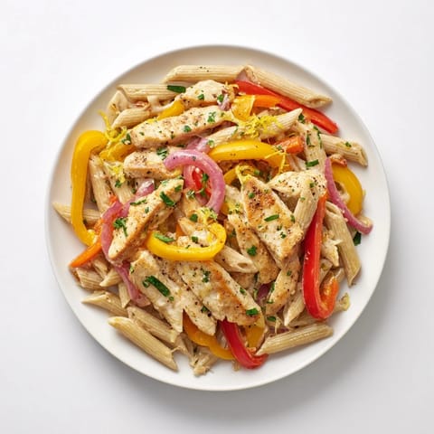 Creamy Cajun Chicken Pasta Lite served in a skillet with colorful bell peppers, fresh parsley garnish, and lightened sauce.