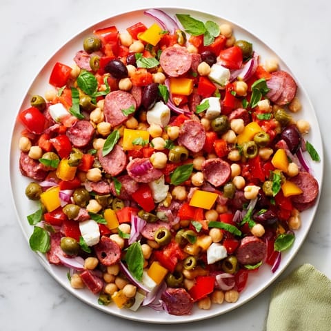 A close-up of the crunchy antipasto chopped salad with chickpeas, salami, mozzarella, and vibrant vegetables tossed in a zesty dressing.  