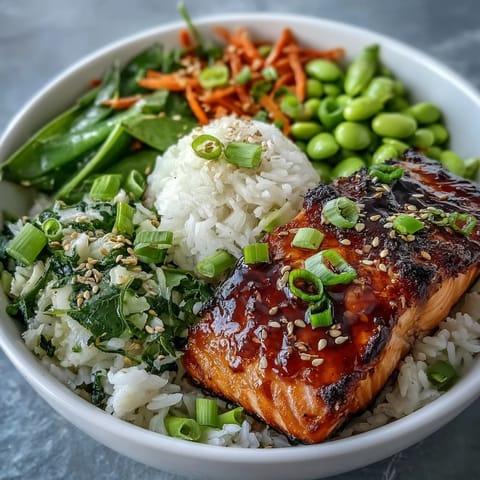 Healthy Asian-inspired salmon bowl featuring flaky soy-ginger glazed salmon atop fluffy rice, crisp vegetables, and a sprinkle of sesame seeds.  