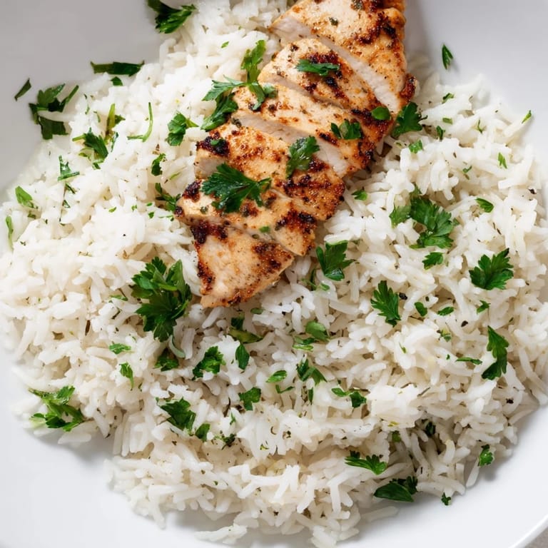 Golden, fragrant garlic butter rice with tender grilled chicken and a bright lemon wedge for serving.