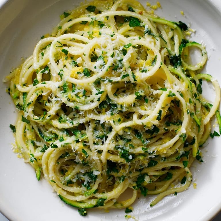 A warm skillet of Lemon Zucchini Pasta glistens with lemon butter sauce, parsley, and garlic, ready to serve for a quick weeknight dinner.
