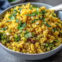 Golden turmeric cauliflower rice, vibrant and fluffy, perfect for healthy grain-free meals.